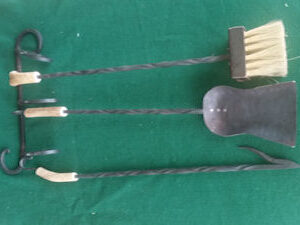 Hand forged fireplace tools with antler handle, including broom, dustpan, and fire poker